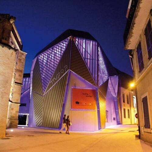 Façades facettées du MuPop éclairées en violet, Montluçon